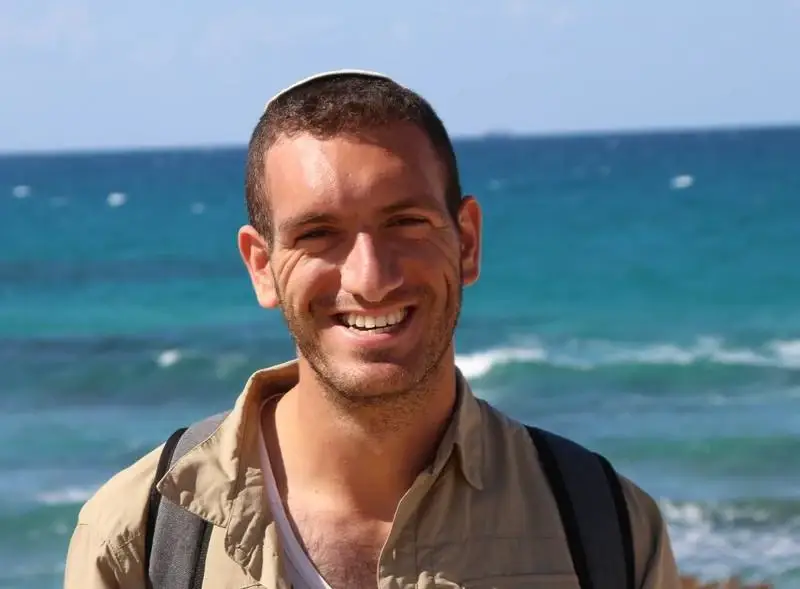 אלון אשר, מנחה סדנאות הפורינג, מחייך על רקע הים